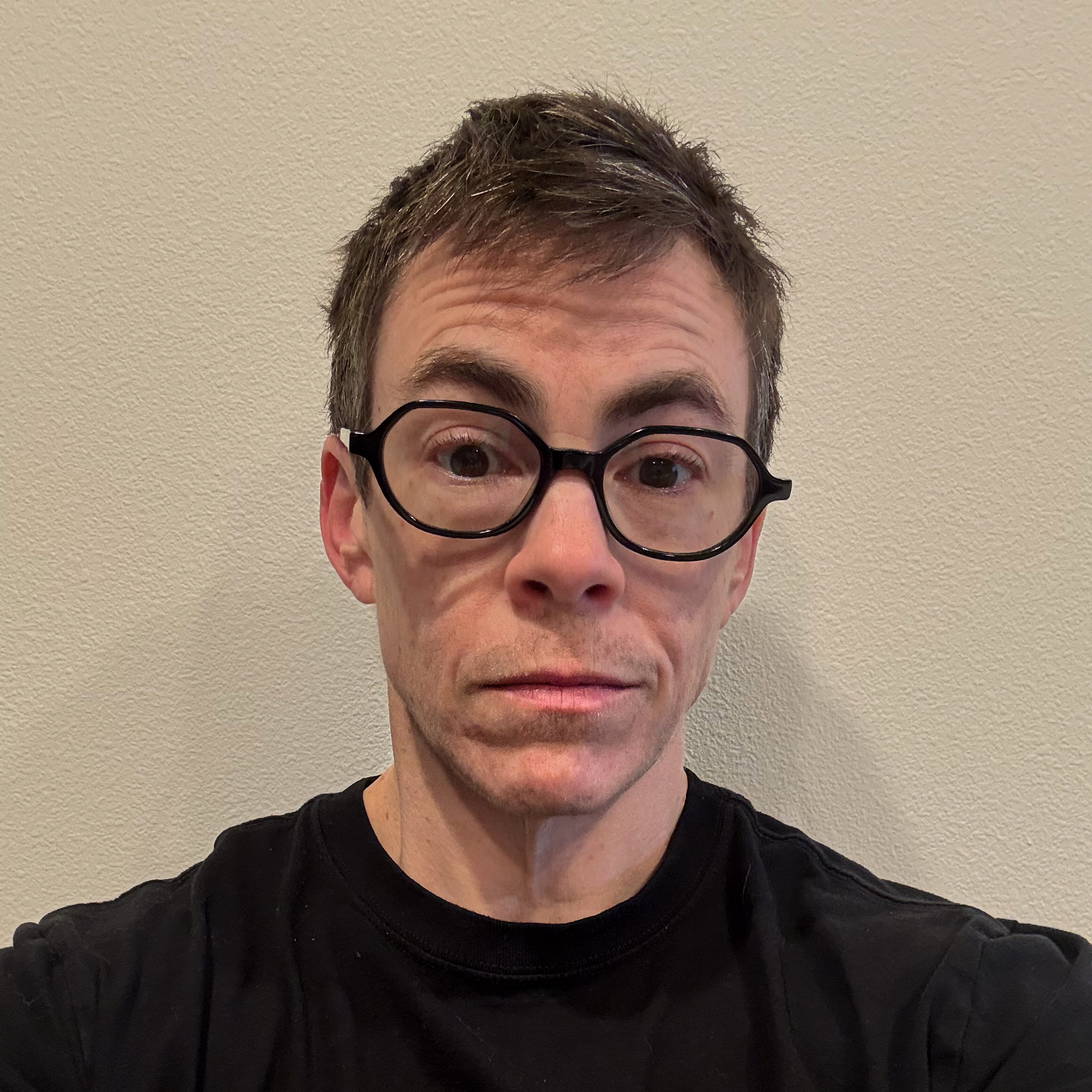 A headshot of Max, a white person with short brown hair and glasses.